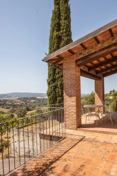 Terrazza di una casa in pietra con vista panoramica sulla campagna collinare.