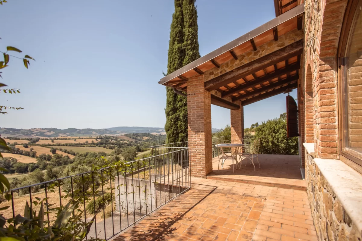 Terrazza di una casa in pietra con vista panoramica sulla campagna collinare.