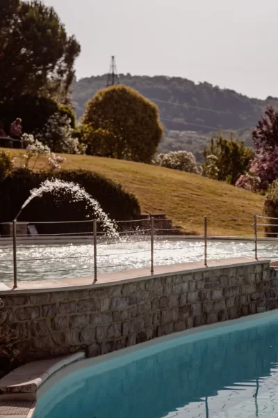 Piscina con cascata in un giardino paesaggistico al tramonto.