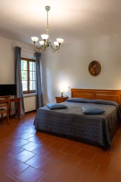 Camera da letto accogliente con letto matrimoniale, arredi in legno e illuminazione soffusa.